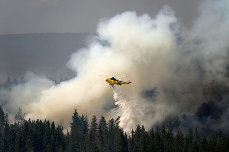 Un helicóptero deja caer agua mientras combate el incendio de Akawa Butte, el 24 de julio de 2026, cerca de Sisters, Oregon. (AP Foto/Noah Berger)