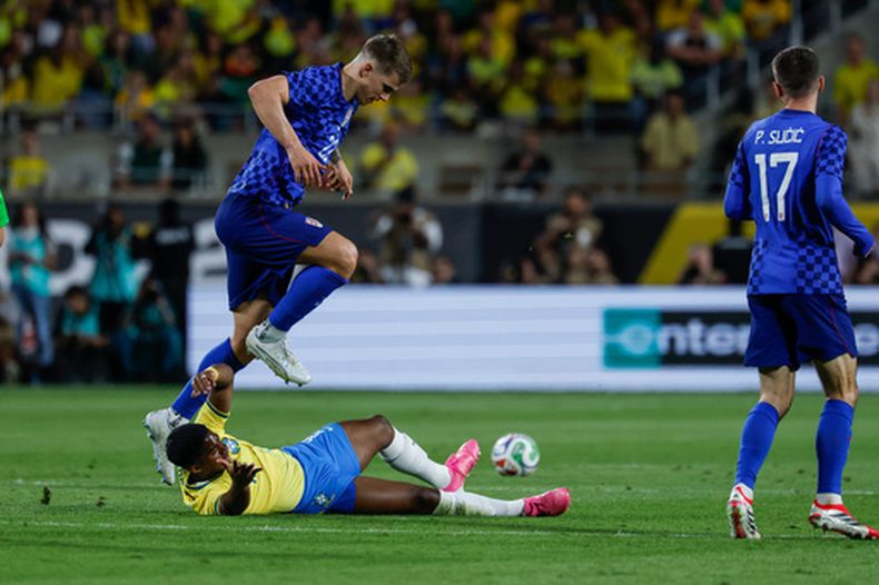 El zaguero croata Luka Vuskovic (22) le comete una falta al delantero brasileño Endrick durante el segundo tiempo de un partido amistoso, el martes 31 de marzo de 2026, en Orlando, Florida. (AP Foto/Kevin Kolczynski)