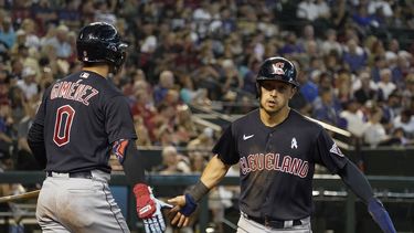 Steven Kwan, derecha, de los Guardianes de Cleveland, es felicitado por Andrés Gímenez en el plato después de anotar en contra de los Diamondbacks de Arizona, durante la cuarta entrada del juego de béisbol, el domingo 18 de junio de 2023, en Phoenix. (AP Foto/Darryl Webb)