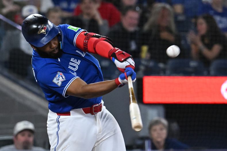 El jugador de cuadro de los Azulejos de Toronto, Vladimir Guerrero Jr. (27), conecta un doble en la sexta entrada de un partido de béisbol de las Grandes Ligas contra los Guardianes de Cleveland, en Toronto, el domingo 26 de abril de 2026. (Jon Blacker/The Canadian Press vía AP)