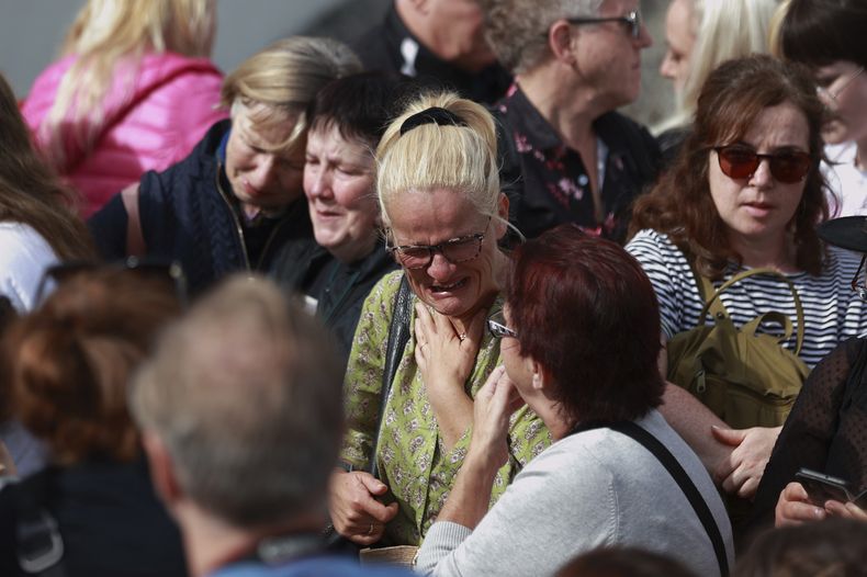 La admiradora de Sinéad OConnor, Ruth OShea, centro, fuera de la casa de la cantante antes de su funeral, en Bray, en el condado de Wicklow, Irlanda el 8 de agosto de 2023. Fans de Sinéad OConnor rodean su cortejo fúnebre en Bray, la ciudad natal de la cantante en el condado de Wicklow, Irlanda, el martes 8 de agosto de 2023. La familia de OConnor invitó al público al paseo marítimo de Bray para despedirse de la artista. (Liam McBurneyPA vía AP)