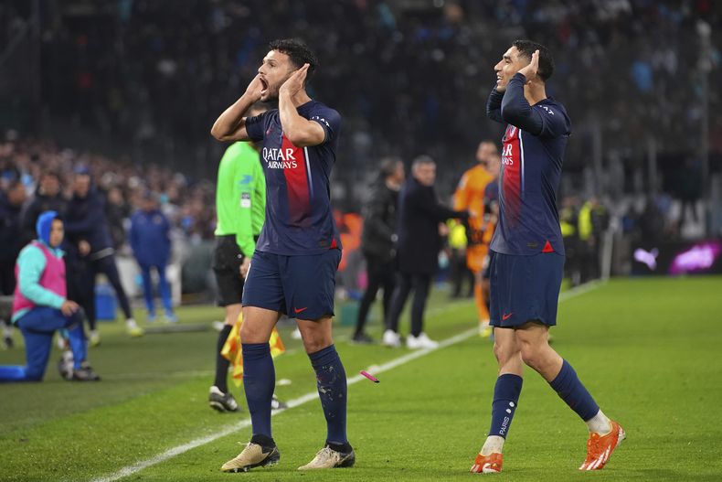 Gonçalo Ramos del PSG (izquierda) celebra junto a su compañero de equipo Achraf Hakimi luego de anotar el segundo gol durante el partido de la Liga de Francia ante el Marsella, en el estadio Velódrome en Marsella, sur de Francia, el domingo 31 de marzo de 2024. (AP Foto/Daniel Cole)