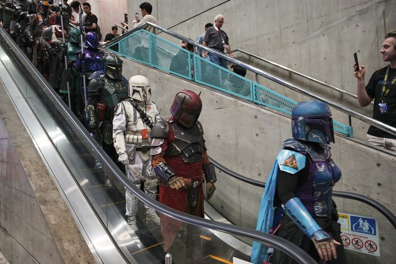 ARCHIVO - Aficionados de Star Wars con diferentes versiones de uniformes de Boba Fett asisten a una convención de aficionados llamada Celebración de Star Wars en Japón, el viernes 18 de abril de 2025, en Chiba, cerca de Tokio. (AP Foto/Hiro Komae, archivo)