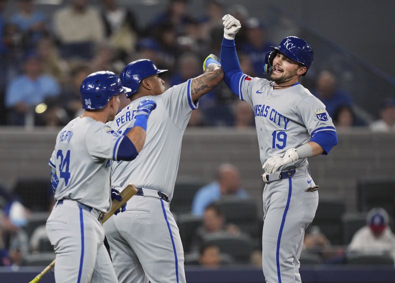 Michael Massey de los Reales de Kansas City celebra con sus compañeros Salvador Pérez (13) y Freddy Fermin tras batear un jonrón de dos carreras ante los Azulejos de Toronto el martes 30d de abril del 2024. (Nathan Denette/The Canadian Press via AP)