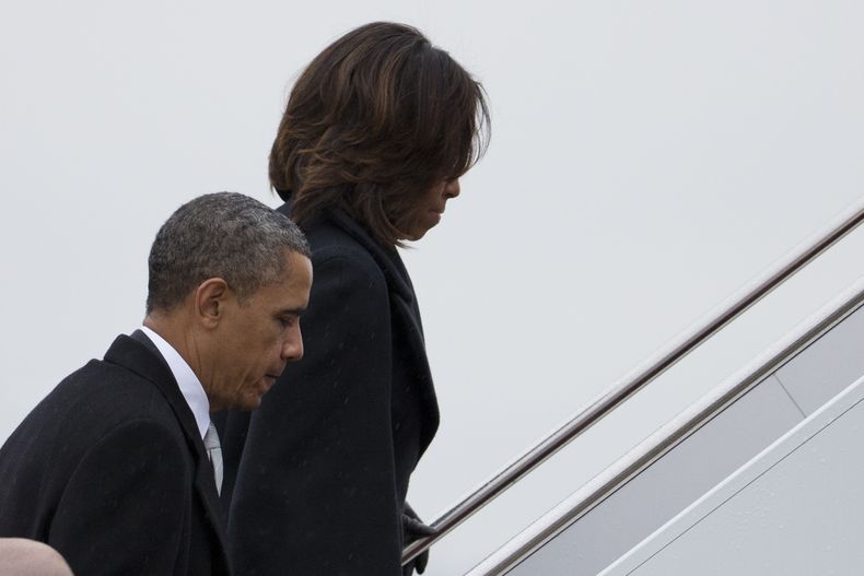 El presidente estadounidense Barack Obama y la primera dama Michelle Obama abordan el avi&oacute;n presidencial en la Base A&eacute;rea Andrews, el lunes 9 de diciembre de 2013, para el viaje a Sud&aacute;frica donde asistir&aacute;n a las honras f&uacute