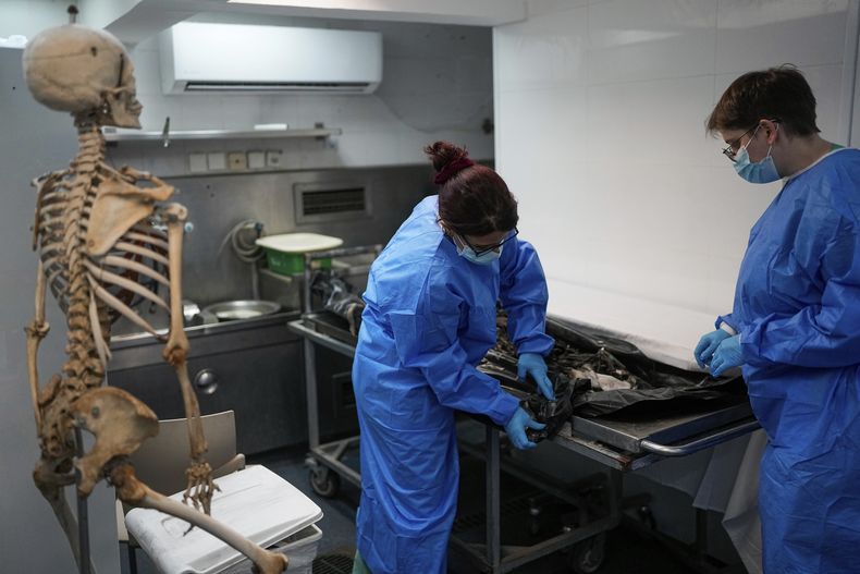 Forenses israelíes examinan los cuerpos de israelíes asesinados por insurgentes de Hamás en el Centro Nacional de Medicina Forense en Tel Aviv, Israel, el 18 de octubre de 2023. El 7 de octubre, más de 1.400 personas fallecieron, en su mayoría civiles israelíes, y unas 240 fueron capturadas en un ataque transfronterizo sin precedentes lanzado por insurgentes de Hamás desde la Franja de Gaza. (AP Foto/Ohad Zwigenberg)