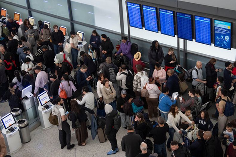 Personas hacen fila en una inspección de seguridad en el Aeropuerto Internacional John F. Kennedy, el domingo 22 de marzo de 2026, en Nueva York. (AP Foto/Yuki Iwamura)