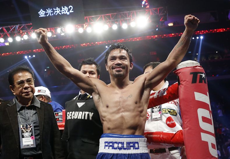 El filipino Manny Pacquiao festeja tras derrotar al estadounidense Chris Algieri para defender su cetro welter por la Organizaci&oacute;n Mundial de Boxeo, el domingo 23 de noviembre de 2014, en Macao (AP Foto/Kin Cheung)