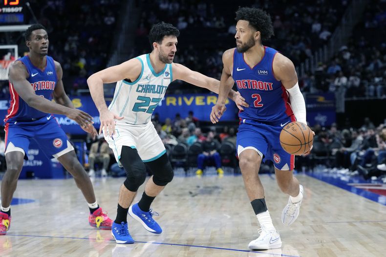 Cade Cunningham (2), de los Pistons de Detroit, sube el balón en la duela mientras Vasilije Micic (22), de los Hornets de Charlotte, defiende durante la segunda mitad del juego de baloncesto de la NBA, el lunes 11 de marzo de 2024, en Detroit. (AP Foto/Carlos Osorio)