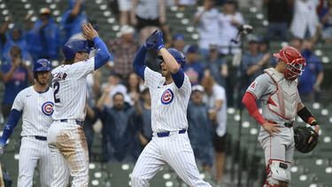 Michael Busch, centro, de los Cachorros de Chicago, celebra con su compañero de equipo Nico Hoerner después de anotar con jonrón de dos carreras mientas el receptor de los Angelinos de Los Ángeles Logan OHoppe, derecha, observa durante la séptima entrada del juego de beisbol del domingo 7 dejulio de 2024, en Chicago. (AP Foto/Paul Beaty)