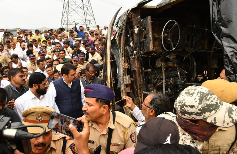 En esta imagen, distribuida por la oficina del ministro en jefe del estado de Maharashtra, muestra al funcionario, Eknath Shinde (delante, de blanco), y al viceministro, Devendra Fadnavis, visitando un autobús incendiado en el distrito de Buldhana, en el estado de Maharashtra, India, el 1 de julio de 2023. (Oficina del ministro jefe del estado de Maharashtra vía AP)