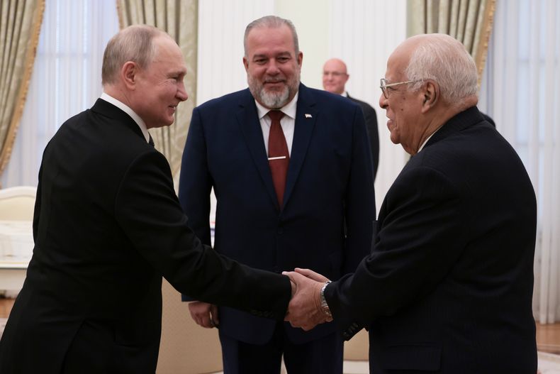 El presidente ruso Vladímir Putin, a la izquierda, saluda a Ricardo Cabrisas Ruiz, vicepresidente del Consejo de Ministros de Cuba, a la derecha, y al primer ministro de Cuba, Manuel Marrero Cruz, antes de sus conversaciones en el Kremlin en Moscú, Rusia, el miércoles 14 de junio de 2023. (Mikhail Metzel, Sputnik, Kremlin Pool Foto vía AP)