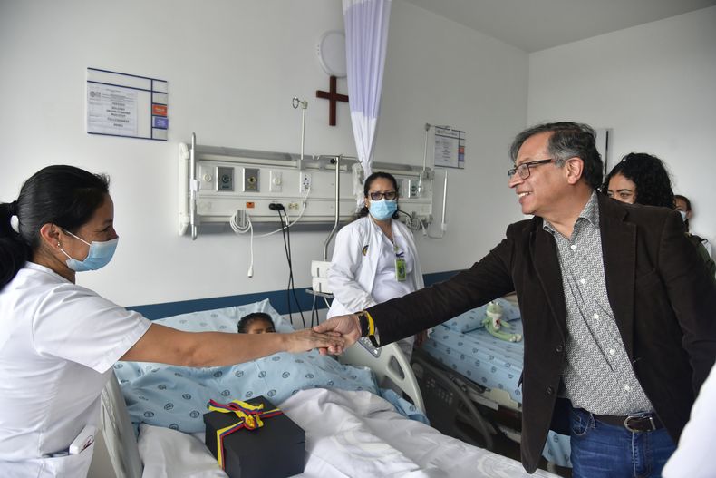En esta foto distribuida por la Oficina de Prensa de la Presidencia de Colombia, el presidente Gustavo Petro saluda a una enfermera que atiende a uno de los cuatro niños indígenas que sobrevivieron a un accidente aéreo en el Amazonía colombiana en el que murieron tres adultos y luego desafiaron la selva durante 40 días antes de ser encontrados con vida, en un hospital militar en Bogotá, Colombia, el sábado 10 de junio de 2023. (Oficina de Prensa de Presidencia de Colombia, vía AP)