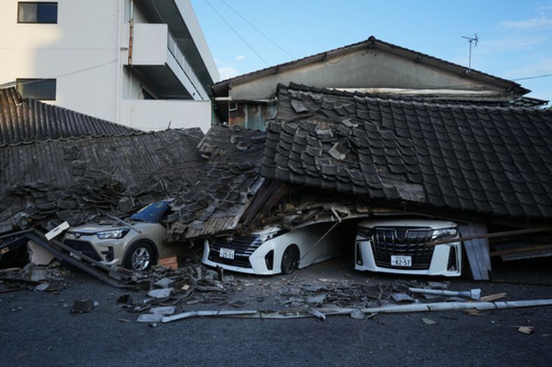 Vehículos aplastados bajo los escombros de edificios, el miércoles 29 de julio de 2026, en Yatsushiro, Japón, un día después de que un sismo remeció la zona. (AP Foto/Hiro Komae)