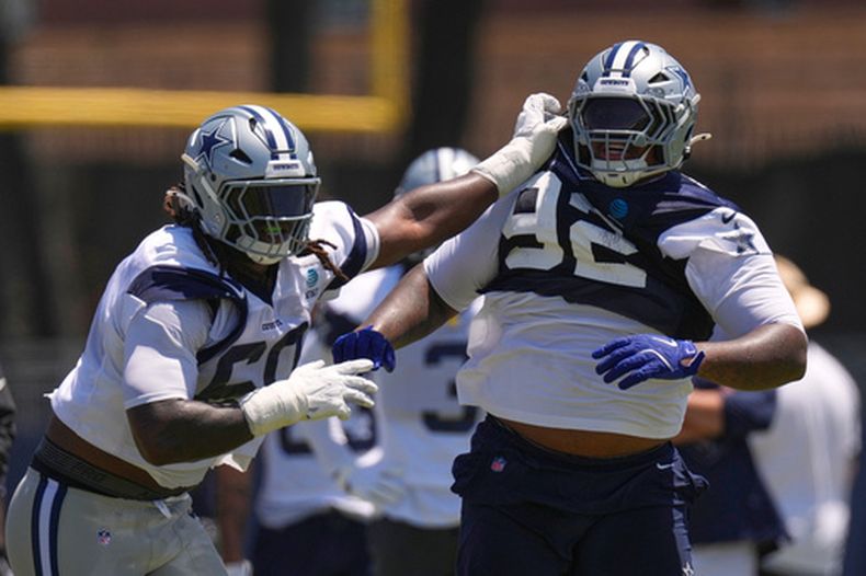 Quinnen Williams (92), tackle defensivo de los Cowboys de Dallas, es sujetado por el tackle ofensivo Tyler Guyton, izquierda, durante un ejercicio en el campamento de entrenamiento del equipo de la NFL, el sábado 1 de agosto de 2026, en Oxnard, California. (AP Foto/Mark J. Terrill)