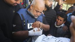 El periodista Wael Dahdouh, centro, de Al Jazeera, sostiene la mano de su hijo Hamza, que también trabajaba para Al Jazeera y quien murió en un ataque israelí en Rafah, en la Franja de Gaza, el domingo 7 de enero de 2024. (AP Foto/Hatem Ali)