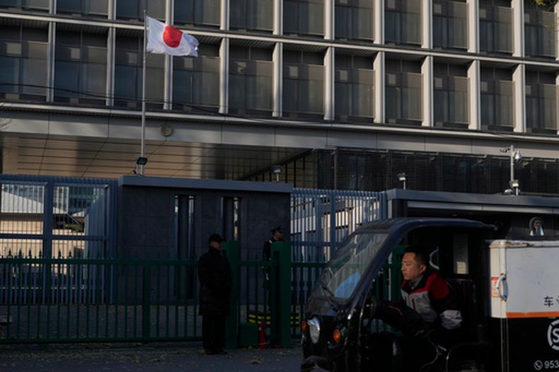Un repartidor pasa ante la embajada japonesa en Beijing el 24 de noviembre de 2025. (AP Foto/Ng Han Guan)
