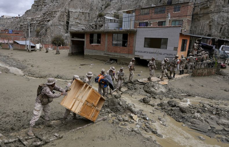 Soldados recuperan un mueble de una casa inundada por un deslizamiento de tierra provocado por fuertes lluvias en La Paz, Bolivia, el domingo 24 de noviembre de 2024. (Foto AP/Juan Karita)