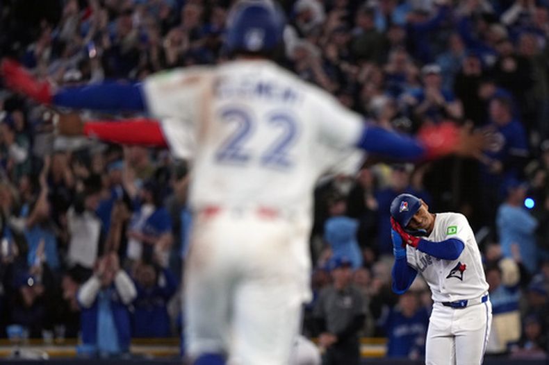 El venezolano Andrés Giménez, de los Azulejos de Toronto, festeja luego de definir con un hit el duelo del viernes 27 de marzo de 2026, ante los Atléticos (Nathan Denette/The Canadian Press via AP)