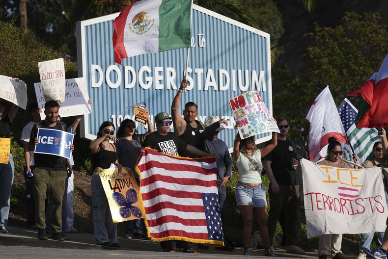 ARCHIVO - Manifestantes protestan contra las redadas migratorias frente al estadio de los Dodgers el 21 de junio de 2025, en Los Ángeles. (AP Foto/Damian Dovarganes, archivo)