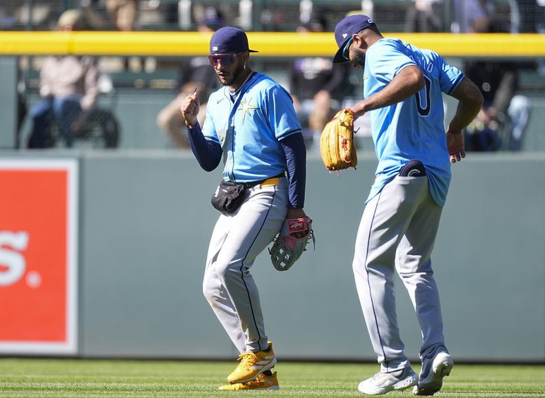 El jardinero central de los Rays de Tampa Bay, José Siri, a la izquierda, baila con el jardinero derecho Amed Rosario después de un partido de béisbol contra los Rockies de Colorado, el domingo 7 de abril de 2024, en Denver. (AP Foto/David Zalubowski)