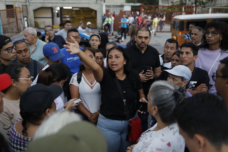 Simpatizantes de la oposición escuchan a la organizadora Deillily Rodriguez mientras se reúnen para ver el conteo de las actas de votación en las elecciones presidenciales en Caracas, Venezuela, el domingo 28 de julio de 2024. (AP Foto/Cristian Hernández)