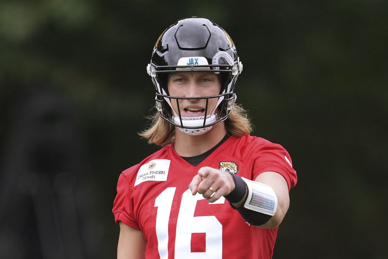 Trevor Lawrence (16), quarterback de los Jaguars de Jacksonville, hace un apunte durente el entrenamiento del equipo de la NFL en The Grove, en Watford, Inglaterra, el miércoles 16 de octubre de 2024. (AP Photo/Kin Cheung)