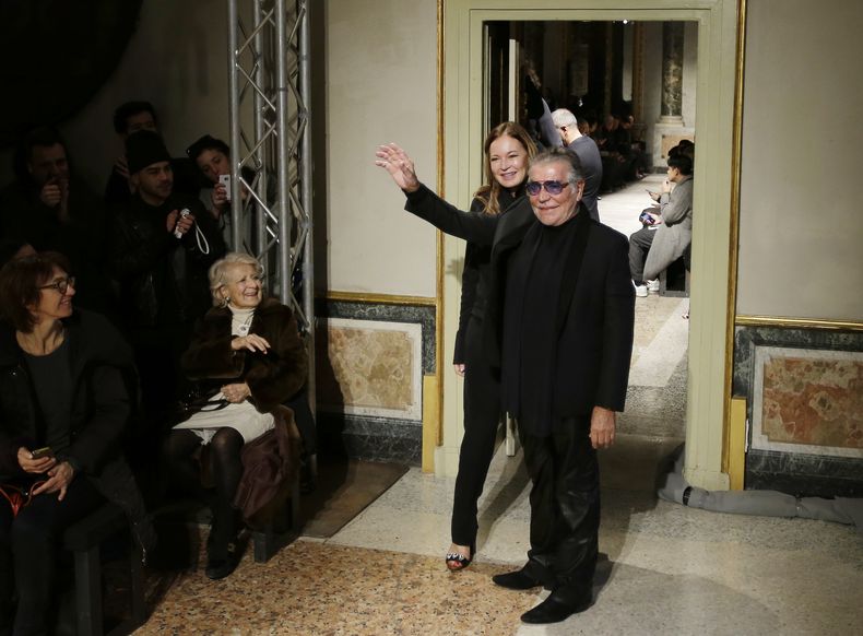 ARCHIVO - El diseñador de moda Roberto Cavalli y su esposa Eva Duringer agradecen los aplausos de la audiencia después de presentar la colección masculina Otoño-Invierno 2015-2016 de Roberto Cavalli en Milán, Italia, el 20 de enero de 2015. Cavalli, conocido por su estilo extravagante y glamoroso, murió el viernes 12 de abril de 2024 a los 83 años, anunció su compañía en una publicación de Instagram. (Foto AP/Antonio Calanni, archivo)