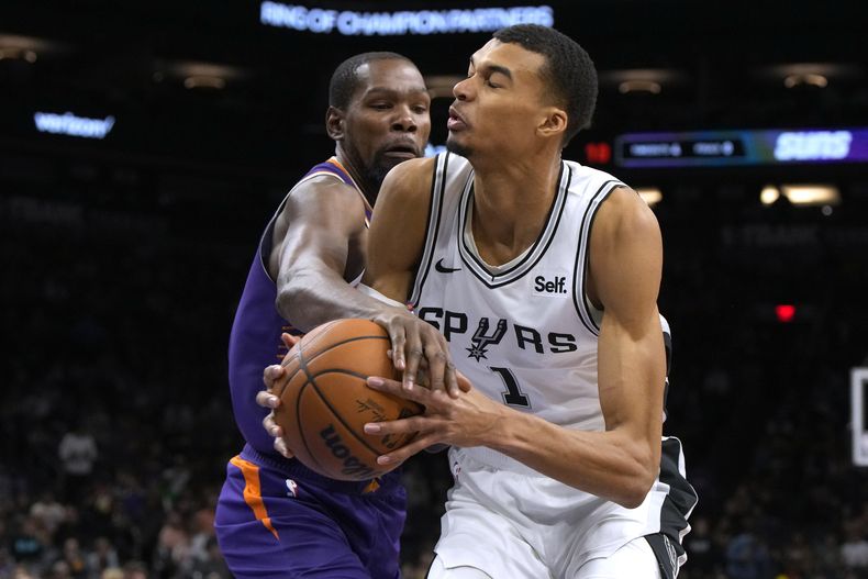 Kevin Durant, de los Suns de Phoenix, comete una falta sobre Victor Wembanyama, de los Spurs de San Antonio, en el partido del jueves 2 de noviembre de 2023 (AP Foto/Rick Scuteri)
