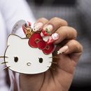 Una fan del personaje japonés Hello Kitty muestra una medalla del personaje creado por Yuko Shimizu, durante la celebración del 50 aniversario, en la Ciudad de México, el domingo 13 de octubre de 2024. (AP Photo/Aurea Del Rosario)