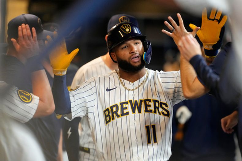 Jackson Chourio de los Cerveceros de Milwaukee felicitado en el dugout por sus compañeros tras batear un jonrón en la primera entrada ante los Rangers de Texas el sábado 29 de agosto del 2026. (AP Foto/Aaron Gash)