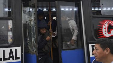 Los viajeros se bajan de uno de los pocos autobuses en funcionamiento durante una huelga del transporte público para exigir que el gobierno proporcione seguridad contra la extorsión en Lima, Perú, el miércoles 23 de octubre de 2024. (AP Foto/Guadalupe Pardo)