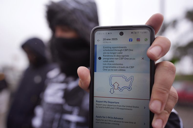 Una persona en Matamoros, México, que solicita asilo en Estados Unidos sostiene un teléfono el lunes 20 de enero de 2025, el cual tiene la app CBP One en la pantalla y muestra que su cita fue cancelada después que Donald Trump asumiera la presidencia de Estados Unidos. (AP Foto/Eric Gay)