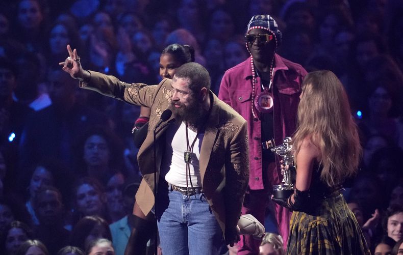 Post Malone, izquierda, y Taylor Swift reciben el premio a la mejor colaboración por Fortnight durante los Premios MTV a los Videos Musicales Awards el miércoles 11 de septiembre de 2024 en el UBS Arena en Elmont, Nueva York. Jordan Chiles, atrás a la izquierda, y Flavor Flav miran. (Foto Charles Sykes/Invision/AP)