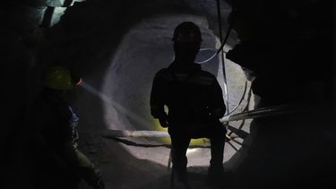 Un minero ilumina una de las cavernas para que sus compañeros puedan ver la salida, en San Joaquín, México, el martes 19 de agosto de 2025. (AP Foto/Fernando Llano)
