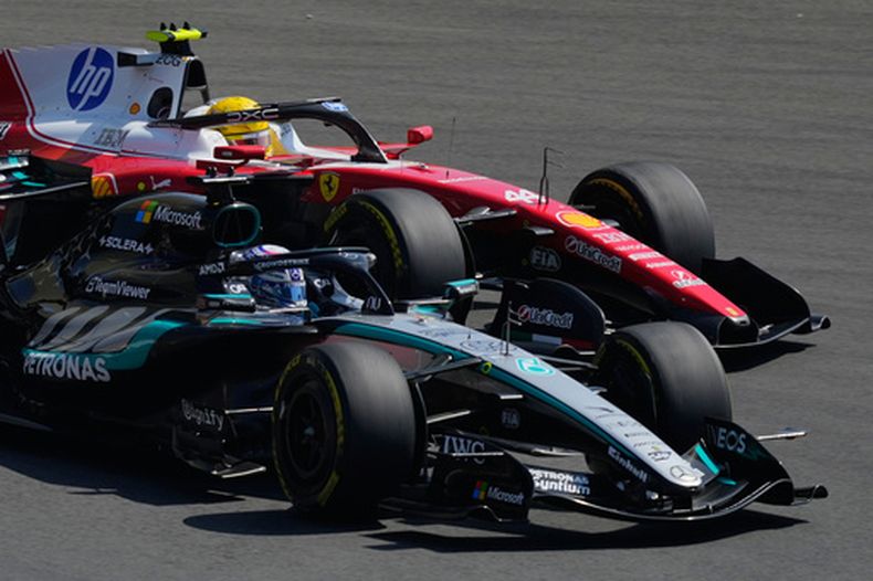 El británico Gerorge Russell (izquierda) disputa en su Mercedes la punta a su compatriota Lewis Hamilton, de Ferrari, durante el sprint del Gran Premio de China, el sábado 14 de marzo de 2026 (AP Foto/Vincent Thian)