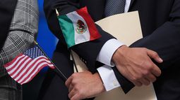 ARCHIVO – Una persona sostiene las banderas estadounidense y mexicana en una conferencia de prensa, en Chicago, el 4 de septiembre de 2025. (AP Foto/Nam Y. Huh, Archivo)