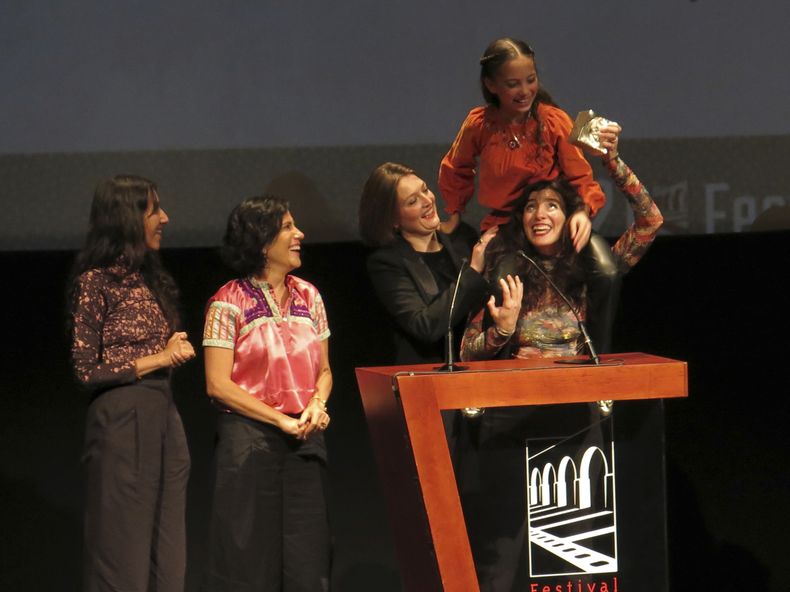 La actriz Naíma Sentiés sobre los hombros de la directora mexicana Lila Avilés al recibir el premio de mejor largometraje mexicano de ficción por Tótem acompañadas por la productora Tatiana Graullera, de izquierda a derecha, la actriz Montserrat Marañón y la productora Louise Riousse en el Festival Internacional de Cine de Morelia, el viernes 27 de octubre de 2023, en Morelia, México. (Foto AP/Berenice Bautista)