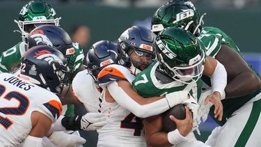 El quarterback de los Jets de Nueva York Justin Fields tacleado por la defensa de los Broncos de Denver en el juego de la NFL en Londres el domingo 12 de octubre del 2025.(AP Foto/Kin Cheung)