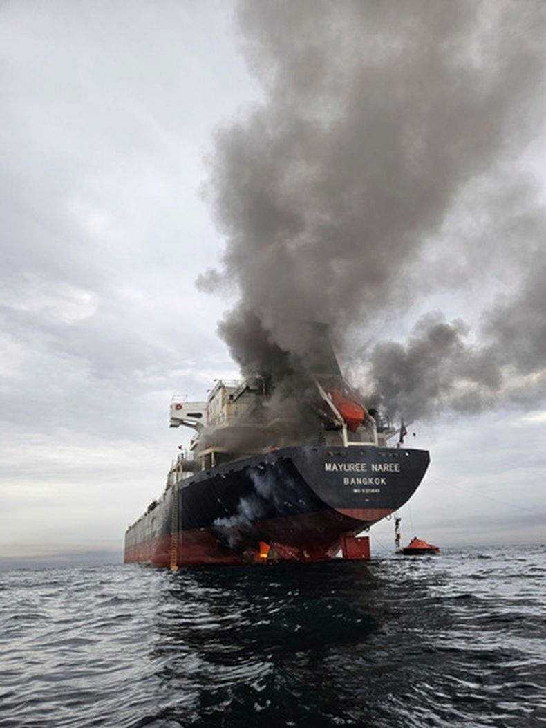 Humo emerge del Mayuree Naree, un buque granelero con bandera de Tailandia, tras ser impactado por un proyectil en el estrecho de Ormuz, al norte de Omán, el 11 de marzo de 2026. (Noppadon Wongsuvan vía AP)