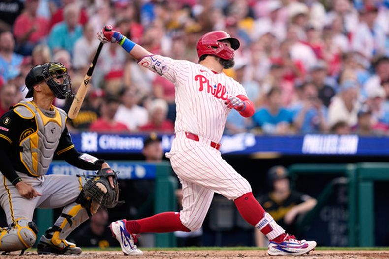Kyle Schwarber, de los Filis de Filadelfia, sigue el vuelo de la pelota después de pegar un elevado de sacrificio que remolcó una carrera frente a Braxton Ashcraft, de los Piratas de Pittsburgh, durante la tercera entrada del juego de béisbol de Grandes Ligas, el lunes 29 de junio de 2026, en Filadelfia. (AP Foto/Matt Slocum)