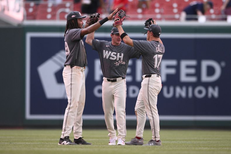 De izquierda a derecha, James Wood, Jacob Young y Alex Call, de los Nacionales de Washington, celebran después de un partido contra los Cerveceros de Milwaukee, el sábado 3 de agosto de 2024, en Washington. (AP Foto/Nick Wass)