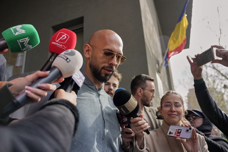 Andrew Tate habla con los medios de comunicación fuera de la Dirección de Investigación del Crimen Organizado y el Terrorismo (DIICOT), en Bucarest, Rumania, el martes 1 de abril de 2025. (AP Foto/Andreea Alexandru)