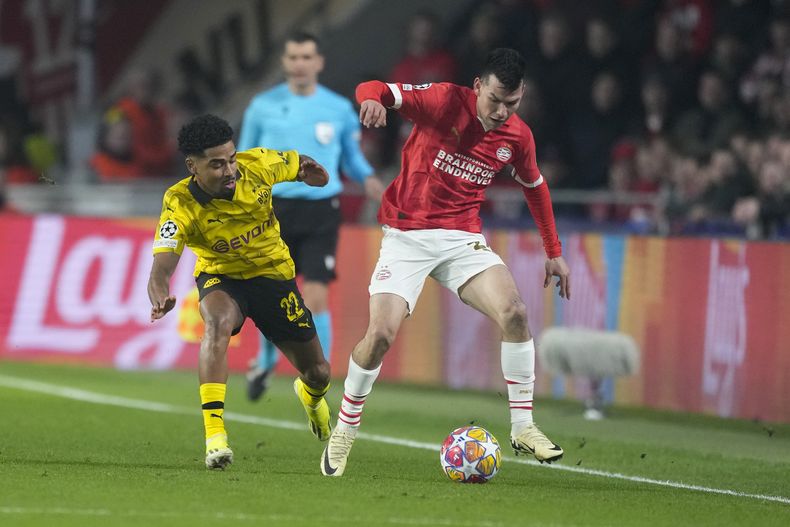 El atacante mexicano Hirving Lozano (derecha) del PSV Eindhoven disputa el balón con Ian Maatsen del Borussia Dortmund en los octavos de final de la Liga de Campeones, el martes 20 de febrero de 2024, en Eindhoven. (AP Foto/Peter Dejong)