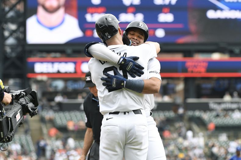 El dominicano Wenceel Pérez, derecha, es abrazado por Mark Canha, después de que bateara un jonrón de dos carreras en contra de los Reales de Kansas City en la primera entrada en el juego de béisbol del domingo 28 de abril de 2024, en Detroit. (AP Foto/Jose Juarez)