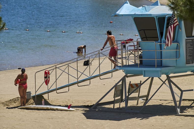 Guardavidas del condado de Los Ángeles vigilan mientras las personas se refrescan en Castaic Lake, el miércoles 20 de agosto de 2025, en Castaic, California. (AP Foto/Damian Dovarganes)