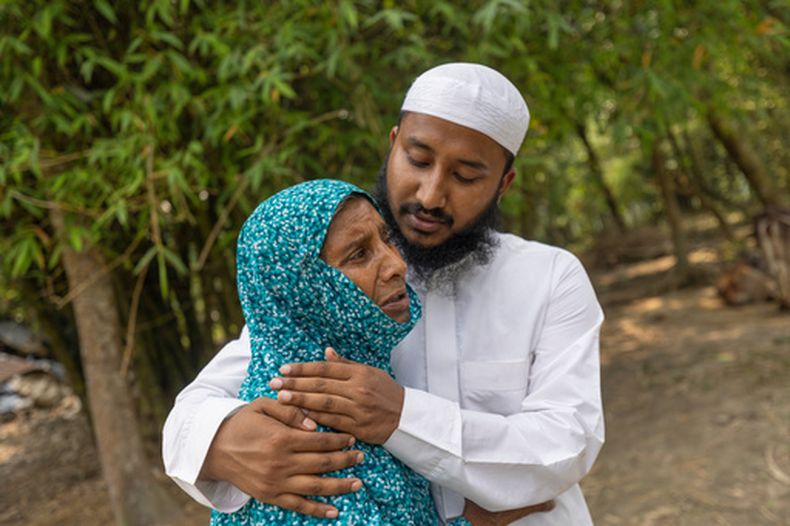 Maruf Hasan, hermano de Mohammad Abdullah Al Mamun, consuela a su madre, Shahida Khatun, mientras llora en su casa del poblado de Rasulpur, en el distrito de Mymensingh, Bangladesh, el viernes 17 de abril de 2026. (AP Foto/Rajib Dhar)