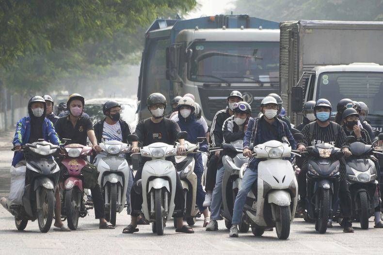 ARCHIVO - Gente con mascarilla espera en un semáforo en Hanoi, Vietnam, el 14 de noviembre de 2024. (AP Foto/Hau Dinh)