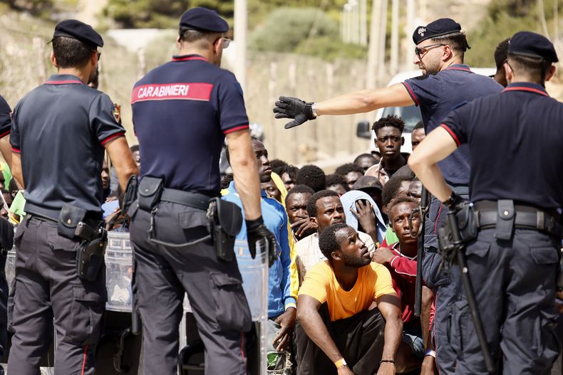 La policía italiana habla con migrantes en un centro recepción en la isla de Lampedusa, en el sur de Italia, el 16 de septiembre de 2023. (Cecilia Fabiano/LaPresse vía AP)