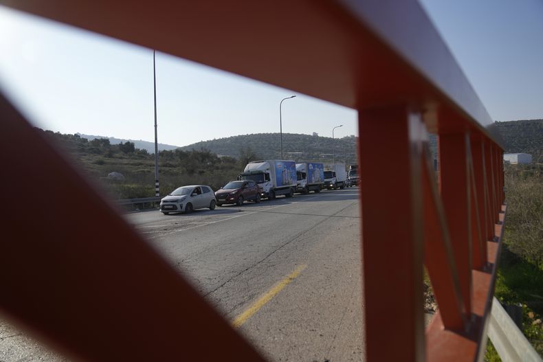 Conductores palestinos esperan en fila en el control militar israelí de carretera de Ein Senia, vistos desde el otro lado de la pueta de hierro al norte de la ciudad cisjordana de Ramala, el miércoles 29 de enero de 2025. (AP Foto/Nasser Nasser)